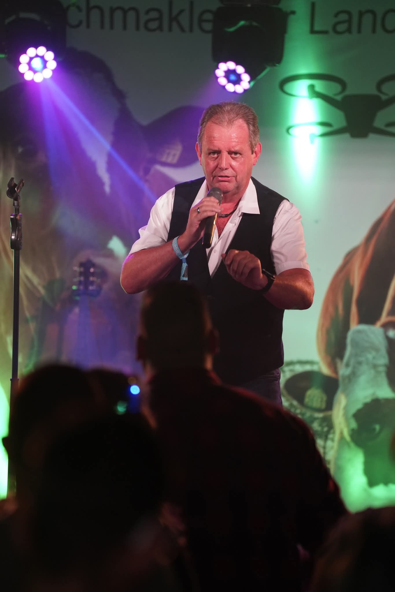 Ne Spetzboov singt bei einer Abendveranstaltung im Bühnenlicht