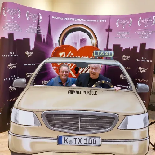 Ne Spetzboov mit Oliver Hoff an der Fotowand des Köln-Musicals „Himmel un Kölle"